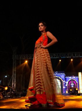 Aralık 2020 'de Yeni Delhi, Hindistan' daki moda fuarında bir model modacı etnik bahar koleksiyonu giyerek podyumda yürüyor.