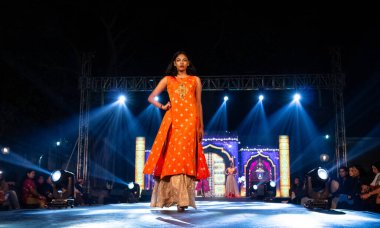 Aralık 2020 'de Yeni Delhi, Hindistan' daki moda fuarında bir model modacı etnik bahar koleksiyonu giyerek podyumda yürüyor.