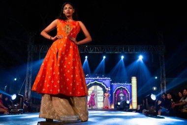 Aralık 2020 'de Yeni Delhi, Hindistan' daki moda fuarında bir model modacı etnik bahar koleksiyonu giyerek podyumda yürüyor.