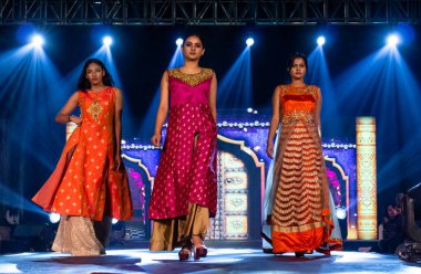 Aralık 2020 'de Yeni Delhi, Hindistan' daki moda fuarında bir model modacı etnik bahar koleksiyonu giyerek podyumda yürüyor.