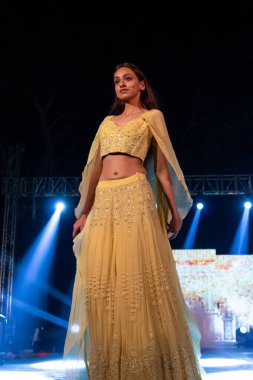 Aralık 2020 'de Yeni Delhi, Hindistan' daki moda fuarında bir model modacı etnik bahar koleksiyonu giyerek podyumda yürüyor.