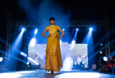 Aralık 2020 'de Yeni Delhi, Hindistan' daki moda fuarında bir model modacı etnik bahar koleksiyonu giyerek podyumda yürüyor.