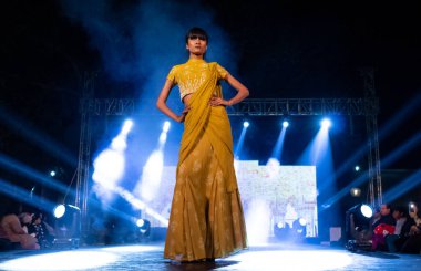 Aralık 2020 'de Yeni Delhi, Hindistan' daki moda fuarında bir model modacı etnik bahar koleksiyonu giyerek podyumda yürüyor.