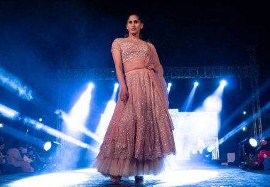 Aralık 2020 'de Yeni Delhi, Hindistan' daki moda fuarında bir model modacı etnik bahar koleksiyonu giyerek podyumda yürüyor.