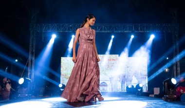 Aralık 2020 'de Yeni Delhi, Hindistan' daki moda fuarında bir model modacı etnik bahar koleksiyonu giyerek podyumda yürüyor.