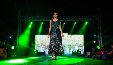 Aralık 2020 'de Yeni Delhi, Hindistan' daki moda fuarında bir model modacı etnik bahar koleksiyonu giyerek podyumda yürüyor.