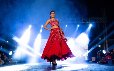 Aralık 2020 'de Yeni Delhi, Hindistan' daki moda fuarında bir model modacı etnik bahar koleksiyonu giyerek podyumda yürüyor.