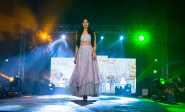 Aralık 2020 'de Yeni Delhi, Hindistan' daki moda fuarında bir model modacı etnik bahar koleksiyonu giyerek podyumda yürüyor.