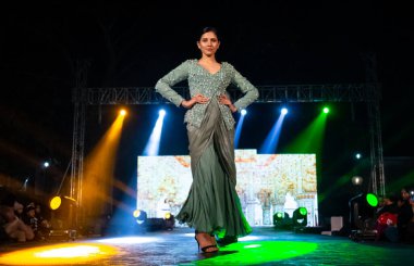 Aralık 2020 'de Yeni Delhi, Hindistan' daki moda fuarında bir model modacı etnik bahar koleksiyonu giyerek podyumda yürüyor.