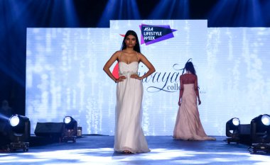 Aralık 2020 'de Yeni Delhi, Hindistan' daki moda fuarında bir model modacı etnik bahar koleksiyonu giyerek podyumda yürüyor.
