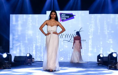 Aralık 2020 'de Yeni Delhi, Hindistan' daki moda fuarında bir model modacı etnik bahar koleksiyonu giyerek podyumda yürüyor.