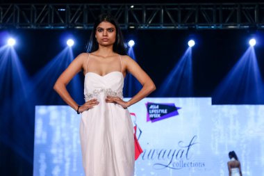Aralık 2020 'de Yeni Delhi, Hindistan' daki moda fuarında bir model modacı etnik bahar koleksiyonu giyerek podyumda yürüyor.