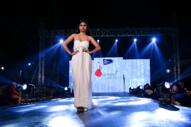 Aralık 2020 'de Yeni Delhi, Hindistan' daki moda fuarında bir model modacı etnik bahar koleksiyonu giyerek podyumda yürüyor.