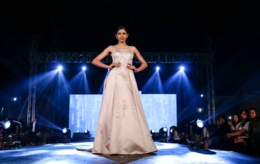 Aralık 2020 'de Yeni Delhi, Hindistan' daki moda fuarında bir model modacı etnik bahar koleksiyonu giyerek podyumda yürüyor.