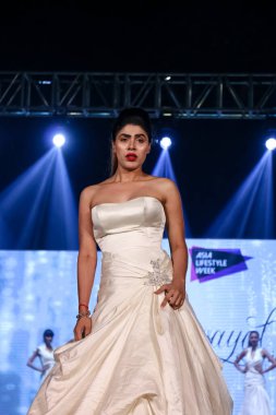Aralık 2020 'de Yeni Delhi, Hindistan' daki moda fuarında bir model modacı etnik bahar koleksiyonu giyerek podyumda yürüyor.