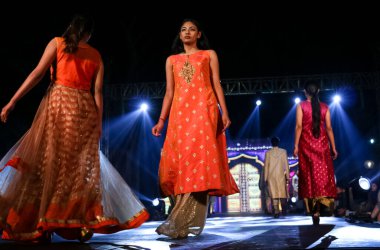 Aralık 2020 'de Yeni Delhi, Hindistan' daki moda fuarında bir model modacı etnik bahar koleksiyonu giyerek podyumda yürüyor.