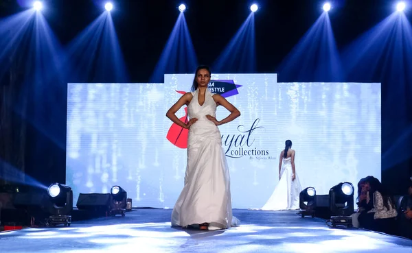 Aralık 2020 'de Yeni Delhi, Hindistan' daki moda fuarında bir model modacı etnik bahar koleksiyonu giyerek podyumda yürüyor.