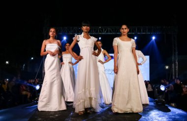 Aralık 2020 'de Yeni Delhi, Hindistan' daki moda fuarında bir model modacı etnik bahar koleksiyonu giyerek podyumda yürüyor.