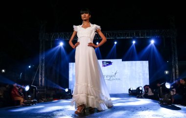 Aralık 2020 'de Yeni Delhi, Hindistan' daki moda fuarında bir model modacı etnik bahar koleksiyonu giyerek podyumda yürüyor.