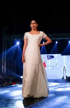 Aralık 2020 'de Yeni Delhi, Hindistan' daki moda fuarında bir model modacı etnik bahar koleksiyonu giyerek podyumda yürüyor.