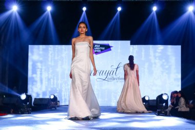 Aralık 2020 'de Yeni Delhi, Hindistan' daki moda fuarında bir model modacı etnik bahar koleksiyonu giyerek podyumda yürüyor.