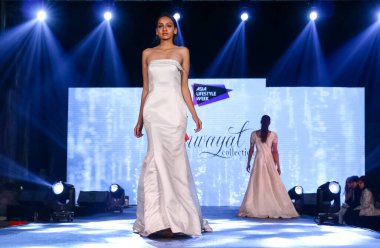 Aralık 2020 'de Yeni Delhi, Hindistan' daki moda fuarında bir model modacı etnik bahar koleksiyonu giyerek podyumda yürüyor.