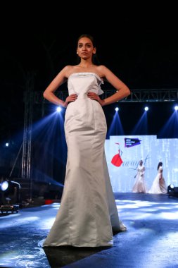 Aralık 2020 'de Yeni Delhi, Hindistan' daki moda fuarında bir model modacı etnik bahar koleksiyonu giyerek podyumda yürüyor.