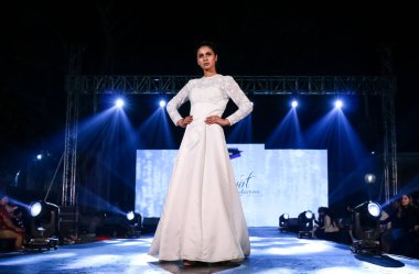 Aralık 2020 'de Yeni Delhi, Hindistan' daki moda fuarında bir model modacı etnik bahar koleksiyonu giyerek podyumda yürüyor.