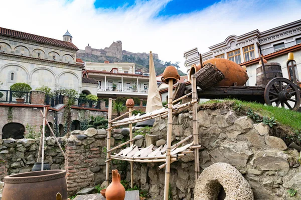 Tiflis Caddesi. Ulusal Gürcü aroması. Sürahiler, değirmen taşları, arba, şarap fıçıları. Georgia.