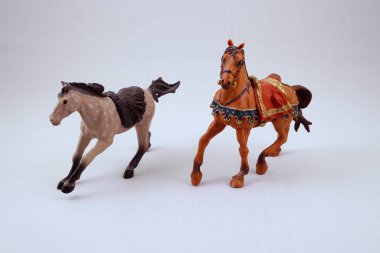 Dört nala koşan küçük oyuncak atlar.
