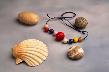 kabuk boncukları ve gri arkaplanda küçük taşlar