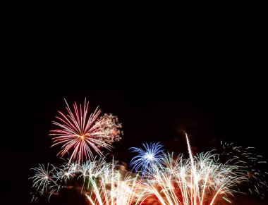 Kırmızı yıldız patlaması, mavi yıldız patlaması altın ve beyaz havai fişeklerin üzerinde siyah arka planda