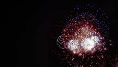 Large red, white, blue, and gold expanding fireworks with a black background clipart