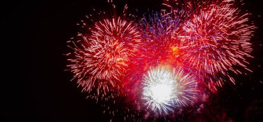 Large expanding red, white, blue,and gold starburst fireworks with a black background clipart