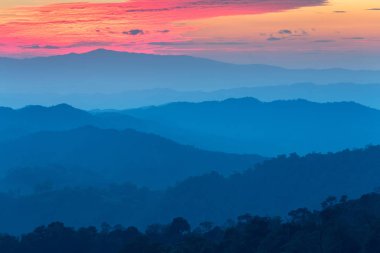 Dağlarda günbatımı zaman gökyüzü yanma ile sis tabakası, 