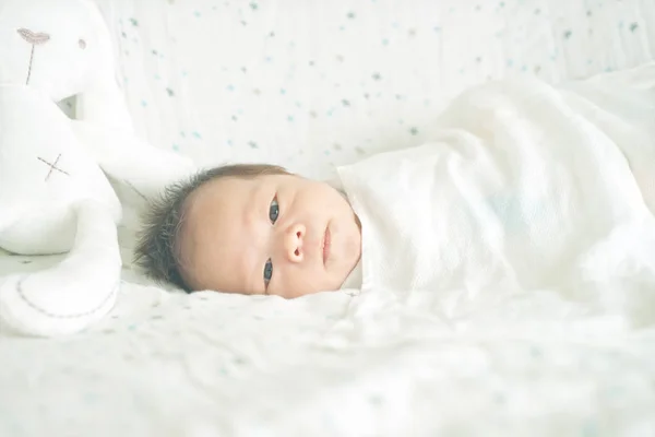 可爱可爱的婴儿男孩裹在毯子或襁褓 有时两只眼睛打开在儿童床上 — 图库照片