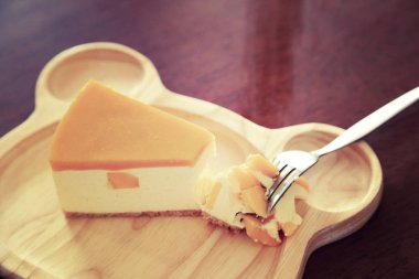 Mango cheesecake ahşap plaka üzerinde parçaları.