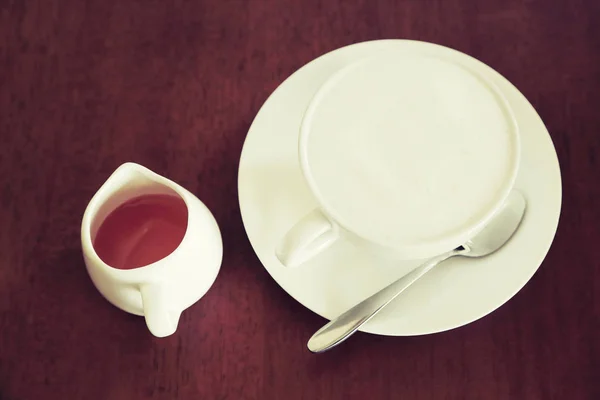 Xícara de café quente com espuma de leite e mel em fundo de madeira . — Fotografia de Stock