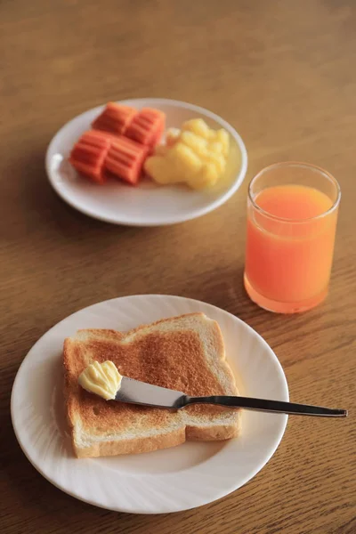 Conjunto de desayuno, plato de tostadas con mantequilla y fruta fresca y zumo de naranja . —  Fotos de Stock