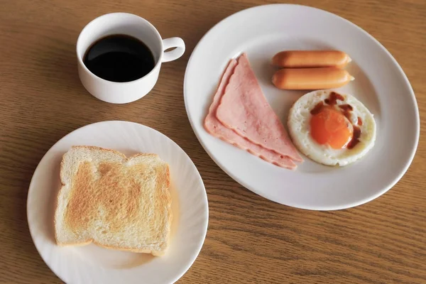 Σύνολο αμερικάνικο πρωινό, τοστ, τηγανητό αυγό, ζαμπόν και λουκάνικο wiith μαύρο καφέ. — Φωτογραφία Αρχείου
