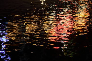 Arka plan dalga su üzerinde renkli ışık yansıması geceleri.