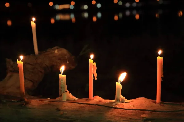 Velas con llama en el tronco con luz bokeh en el fondo . —  Fotos de Stock