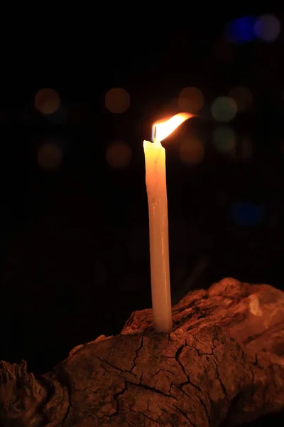 Kerze mit Flamme auf Baumstamm mit Licht Bokeh auf Hintergrund. — Stockfoto