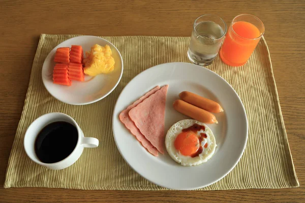 Conjunto de desayuno americano en mesa, huevo frito, jamón y salchicha — Foto de Stock