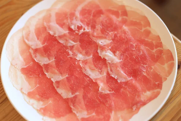 Rauw varkensvlees gesneden in witte schotel voor shabushabu, Japanse recept. — Stockfoto