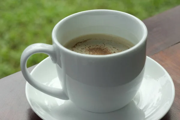 Чашка кофе на деревянном столе в саду . — стоковое фото