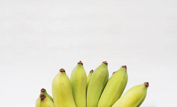 Stelletje geteelde bananen of Thaise bananen op wit met houten — Stockfoto