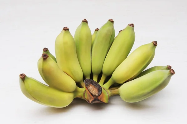 Stelletje geteelde bananen of Thaise bananen op witte houten rug — Stockfoto