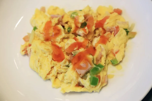 Omelet bij het ontbijt met ham, groene paprika's en tomaten. — Stockfoto