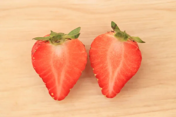 Schneiden Sie frische Erdbeeren auf Holz Hintergrund. — Stockfoto